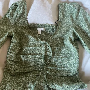 Blommig topp - Säljer denna superfina vår och sommartoppen. Toppen är i mjukt material och en fin grön färg. Använd fåtal gånger så skicket är som ny. Finns inte kvar att köpa. Säljer då den inte passar mig i strlk💚💚