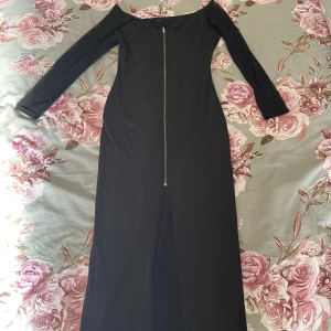 Klänning - Säljer denna otroligt snygga lång klänning som man även kan ha som kofta. Armarna är av mesh. Och den är delad där fram som ni ser.  