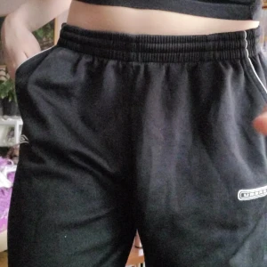 Vintage Umbro joggers - Inköpt mellan år 2000-2010. Vintage Umbro joggers med två loggor, en på varje ben. Tapered med lös passform. Dragkedja vid varje benöppning. Använt skick, men fina. Passar M men även S (lite större då). Svarar på alla frågor.
