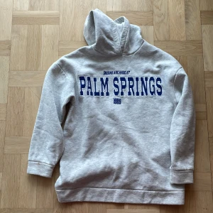 Hoodie från gina - En grå Hoodie från Gina med blått tryck. Storlek 158-164 så passar en xxs och xs. Använd ett par gånger och är i bra skick.