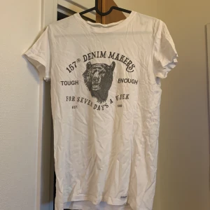 Vit t-shirt  - En vit t-shirt med ett tryck på 