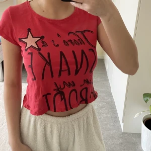 Cropped T-shirt  - Supersnygg croppad röd tshirt. Är i mycket bra skick. Har endast en liten rand som knappt syns. Text ”theres a snake in my boot”. Frakt tillkommer. Skriv gärna vid frågor ❤️