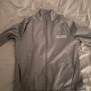 Hugo boss zip hoodie grå storlek S gamla modell. Använder ej längre då jag växt ur den. Bra skick.
