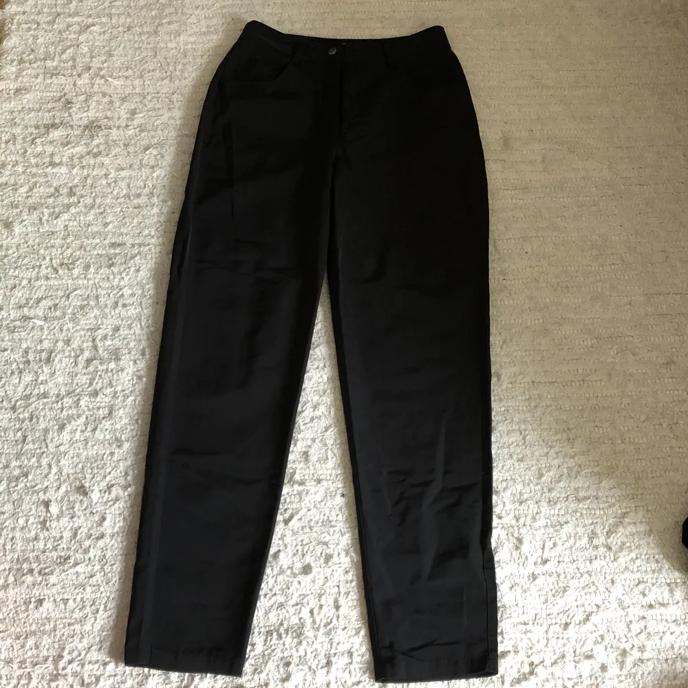 Svarta byxor (ser nästan ut som kostymbyxor) med fickor fram och bak. Jeans & Byxor.