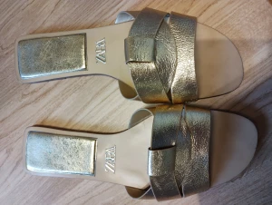 Sandaler från Zara  - Fina sandaler i guld från Zara , endast använda 2 ggr , inköpta för några veckor sen , slut i butik . Nypris 359 kr . Strl 39 