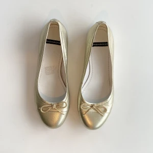 Guldiga ballerina skor - Guldiga ballerina skor ifrån märket vagabond, storlek 37 (passar 36 också)  Helt perfekta, nyskick  Säljer då dem tyvärr är försmå till mig