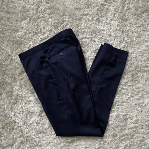 Kostymbyxor herr - Fina mörkblå kostymbyxor i Slim fit storlek W30 L32. Använda en gång. 