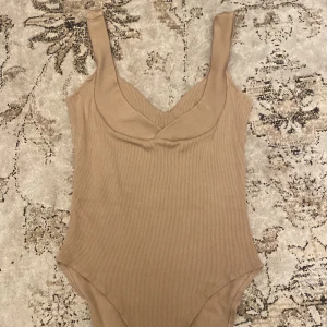 Body från H&M - Beige body från h&m i fint skick, storlek S