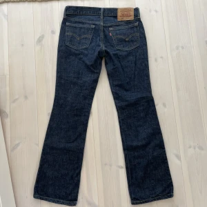 Lågmidjade bootcut Levis jeans - Säljer dessa superfina mörkblå Levis jeans. Säljer pågrund av att de har blivit för små. Midjemått: 76 cm Innerbenslängd: 72 cm