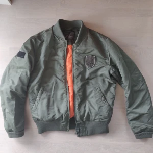 Bomberjacka - Fin grön bomberjacka från jack&Jones. Sparsamt använd så bra skick. Avtagbar krage. Nypris 900 Storlek small herr