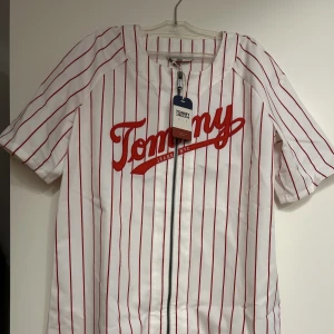 Tommy Jeans Baseball Dress - En oanvänd jättefin klänning i storlek XS men den är stor i storleken så passar S och M. Vid fler frågor kan ni gärna kontakta mig. :)
