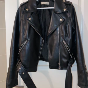 Svart Skinnjacka - En svart skinnjacka med silver detaljer. Säljer då den är för liten. Pris går att diskuteras. Inga skador eller fläckar. 