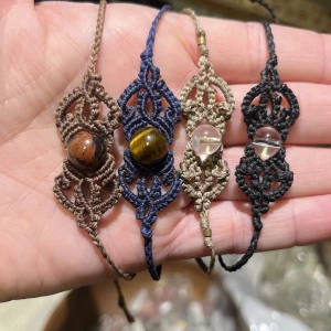 Nya! Ställbara Makramé armband med kristll pärlor. Pris per st - Nya handgjorda armband i makramé med äkta kristall pärlor. Ställbara.   (beiga är provat och snörena något kortade) Från vänster till höger: Brunt band med mahogny obsidian Mörkblått band med tigeröga Beige band med bergskristall  Svart band med -||-