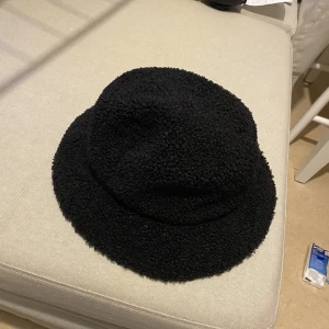 Bucket hat  - Bucket hat med ”teddy tyg”. Använd ett fåtal gånger  