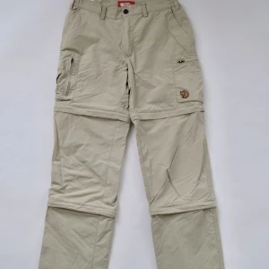 Vintage Fjällräven Zip Byxor - Säljer dessa Fjällräven ”3 stage zip trousers” Väldigt bra skick! Nästan nya. Man kan dela upp dem i 3 olika sektioner, funkar även att ha som shorts! Perfekt för vardagen eller för arbete/ rörelse! Kan gå ner lite i pris vid snabb affär! Bilder i DM!💪⭐️