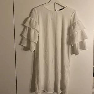 Klänning - Vit klänning från only med volangärmar i storlek 36. Mindre "slitage" syns på bild 3. Finns en del sånna runtom klänningen