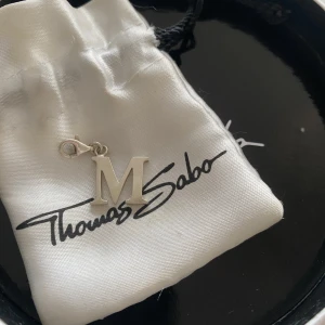 Berlock  - Säljer detta M berlocken. Kommer inte till användning längre❤️ box till kommer tyvärr inte men finns signatur av Thomas sabo på berlockerna❤️orginalpris : 300kr