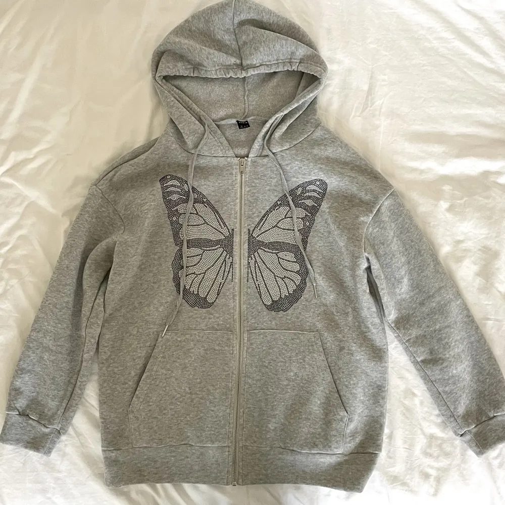 Populär grå zip up hoodie från shein med en fjäril på. Använd få gånger, inga defekter och är i nyskick. Köpt för 219kr men säljer för 50kr.. Hoodies.