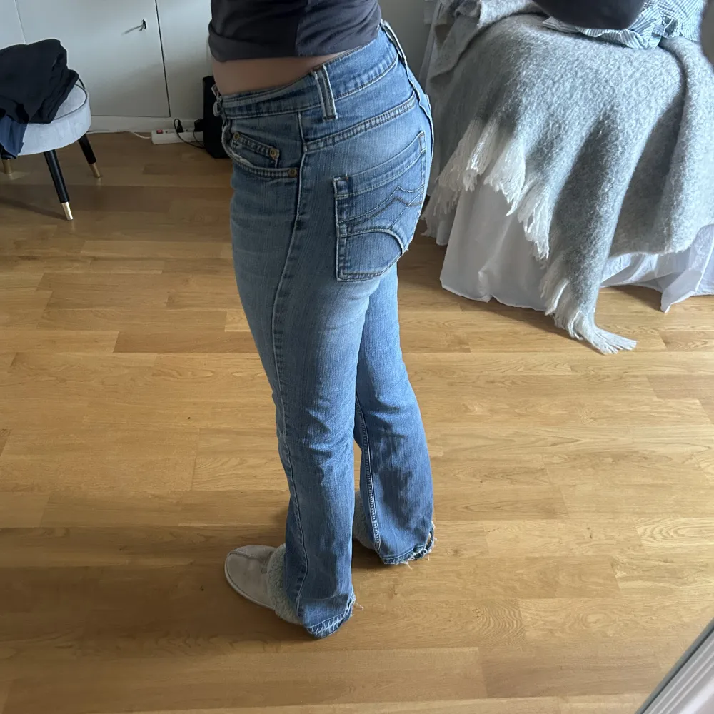 Ett par Bootcut jeans som är mid waist. En hälla på jeansen är trasig och på ena benet längst ned har det gått upp. Se bild 2. Annars i bra skick.. Jeans & Byxor.