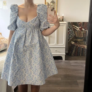 Klänning med puffärm - Klänning med puffärm och vid kjol samt fickor. Har jättefin låg rygg och stretch baktill. Är av tjockare material och passar till fest :)