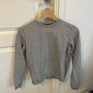 Grå sweatshirt  - Grå sweatshirt som är i nyskick och är knappt använd, säljs pågrund av att den inte kommer till användning 