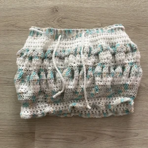 Kjol - Blå och vit kjol med snöre så man kan justera hur liten man vill ha den. Den är handgjord (virkad).