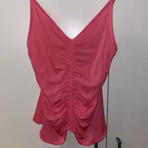 Jättesöt rosa topp med draperad detalj i mitten. Justerbara axelband. Använt några gånger. Köpt från H&M. Strl S.