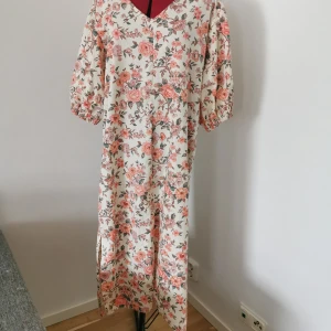 Maxiklänning med slits - En bomullsblommig härlig klänning med slits, som slutar vid fotknölarna på mig som är 168cm.  Materialet är återbrukat och sydd utav mig.  Storleken sitter med vanlig passform på mig och jag är en L/XL, dock fungerar den utmärkt i fler storlekar. 