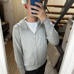 Grå zip hoodie  - En grå ziphoodie som funkar till allt. Bra och skönt material och bra kvalite då den är inte så använd. Även väldigt bra passform. Säljs inte längre i butik eller nätet så passa på! 