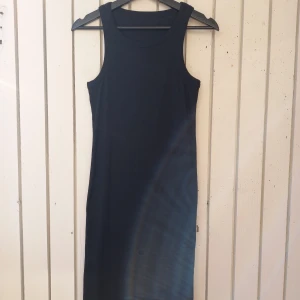 Long sleeveless stretchy dress - Black stretchy dress, size L. Goes below the knee.  98% cotton, 2% elastan (the label was cut off).  Length 100 cm Underarm width (unstretched) 36 cm×2 Underarm width (fully stretched) 56 cm×2 Width between outer edges of the straps (shoulder width) 28 cm