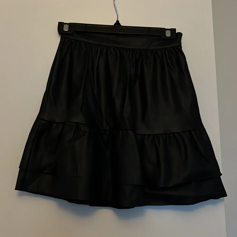 Söt svart skinn/läder kjol från NA-KD. Fint skick och använd fåtal gånger. Storlek 32. Kjolar.