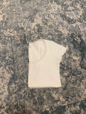 Brandy Melville McKenna Bow Top - En broderat t-Shirt ifrån Brandy Melville Ribbad