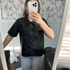 Fake skinn skjorta - En skjorta i fake skinn med korta ärmar.