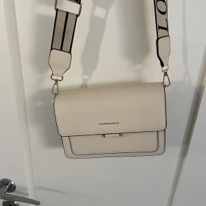 Väska  - En väska med justerbara band. Många praktiska fickor och gott med utrymme. Har aldrig använts och är i mycket bra skick. 😊