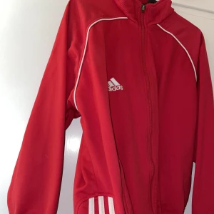 Adidas - Röd Adidas tröja i bra, dragkedjan e lite paj men den funkar att dra upp och ner som vanligt!