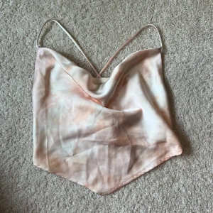 Linne i satin med knytning  - Linne i en ljusrosa/ orange färg med knytning bak i ryggen