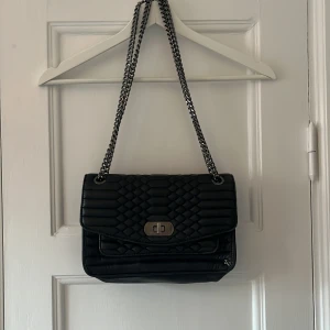 Zadig & Voltaire väska - Så fin axelväska från Zadig! Går att ha crossbody eller på axeln. Väskan är i skinn med svarta detaljer och är i använt men fint skick! Väskan har många fack och om man önskar fler bilder av insidan så är det bara att skriva <3 Måtten för väskan: 26 x17x8