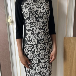 Trendig klänning - Klänning som trollar och gör dig smalare genom att i sidorna är det svart tyg och fram och bak är det stormönstrat. Super snygg! Storleken passar både S och M men märkt med XS. Rök o djurfritt hem kommer den ifrån.