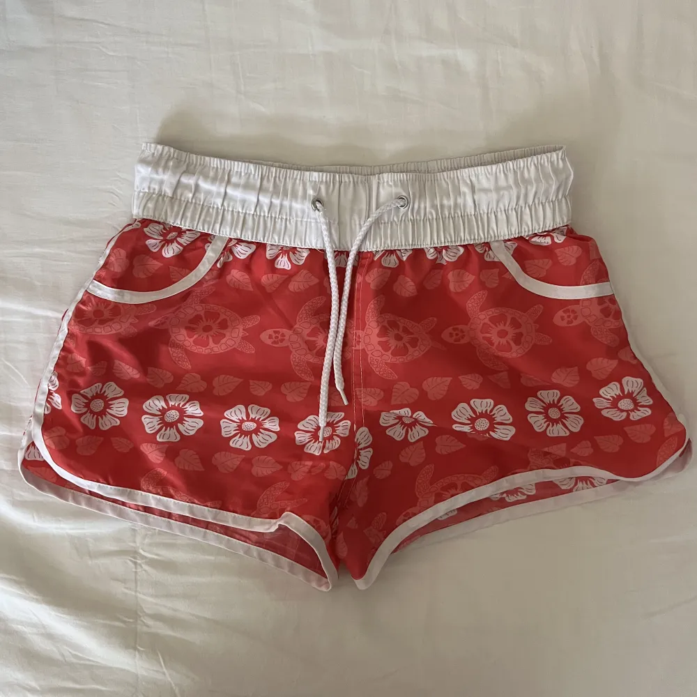 As coola rosa Hawaii shorts, perfekta som cover up när man ska till strand eller brygga! Lite lösa trådar på snöret, dock inget som påverkar funktionaliteten. Passar XS-S🫶💕. Shorts.