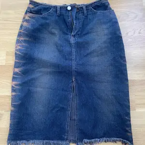 Jeans kjol med glitter detalj på sidorna. Midi- till knäna. Mörkblå jeans 