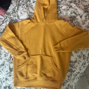 Gul hoodie  - Säljer denna hoodie eftersom den knappast används längre. De finns även en liten mörkgrön fläck på en armen.