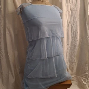 Blå glittrig klänning med volanger - Str 146/152 men kan passa xs-s, kanske m. Pris är diskuterbart vid snabb affär. 💖Slutar vid låren. Vid funderingar skicka gärna pm. 😊