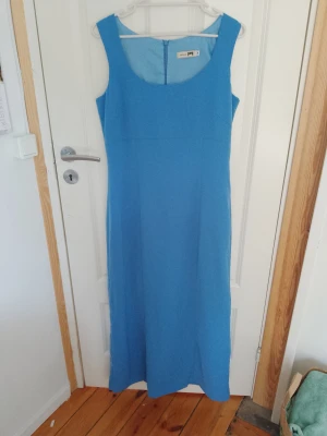 Blå lång klänning  - En blå långklänning i storlek 38. Passar mig som är 168cm. 100% polyester. Är oanvänd.