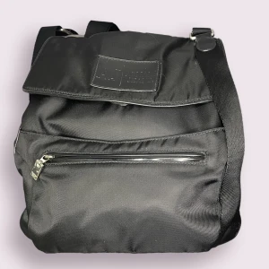 Armani jeans väska  - Axel väska från armani .äkte men har inget kvitto har serie nummer om du frågar. Cond 7/10. Har många fickor.