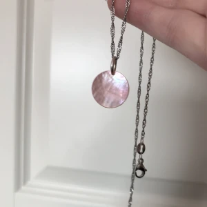 Rosa snäckskal halsbandshänge  - Rosa halsbandshänge av rosa pärlemor skal. Nytt, oanvänt och handgjort. Kontakta gärna vid frågor. Har också andra smycken på min profil.🌺