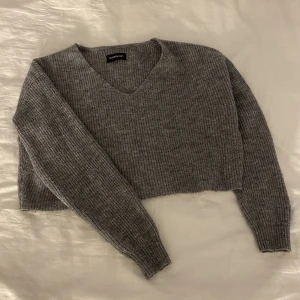 Gråstickad tröja med v-krage - Använd några gånger men är i ett bra skick. Fin till vita byxor.