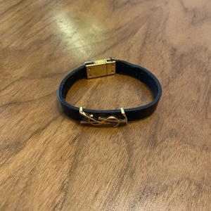 Yves saint laurent  - Svart armband Yves saint laurent kvinna sitter bra på armen, bra skick 