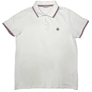 Moncler, Piké - ✨Vit, helt fläckfri, Moncler Piké. Loggan i superfint skick och självklart fungerar CLG-koden! Storleken är L men passar M utan problem✨  Sthlmtrend.se