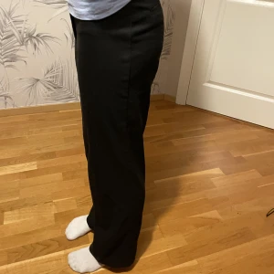 Svarta Kostymbyxor  - Svarta kostymbyxor i storlek 34 från Monki. Högmidjade byxor, bra skick knappt någon användning då dom är försmå. 