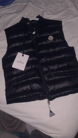Moncler väst - Säljer nu min moncler väst pga av att den inte kmr t användning längre. Nfc Scan på märket och även lappen samt en qr kod. Västen är i storlek S. Skriv gärna för fler frågor
